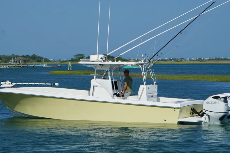 Slide: The Image of 2025 Competition 31 boat cruising on a serene waterway with fishing rods and Suzuki engine. - 3