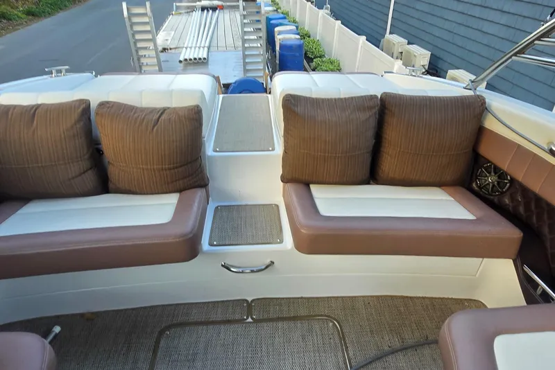 Slide: The Image of 2013 Cobalt 296 boat interior with cushioned seating and brown pillows. - 4
