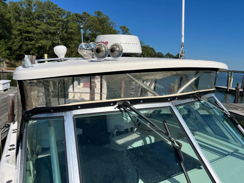 Slide: The Image of The 2008 Pursuit OS 285 Offshore is docked. It features a sturdy hardtop and clear windows. - 32