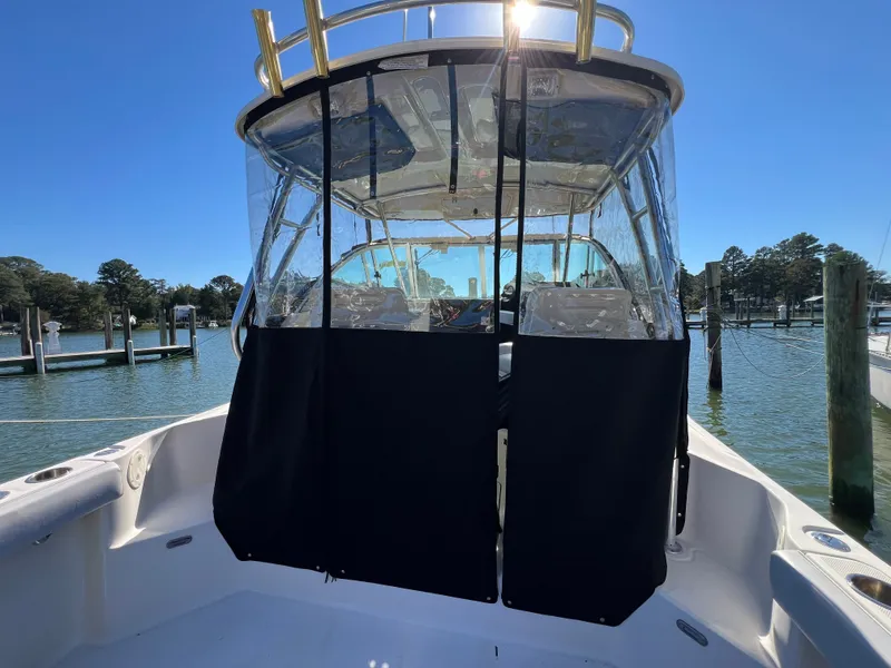 Slide: The Image of The image shows a 2008 Pursuit OS 285 Offshore boat with an enclosed cabin at a dock. - 36