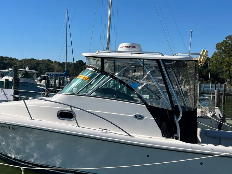 Slide: The Image of 2008 Pursuit OS 285 Offshore in a marina, with clear skies and surrounding boats. - 29