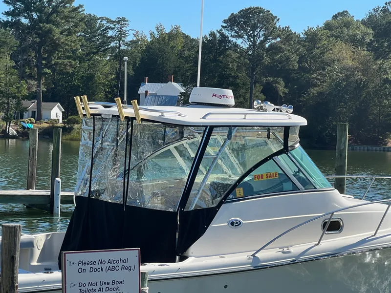 Slide: The Image of A 2008 Pursuit OS 285 Offshore is docked in a tranquil setting surrounded by trees. - 31