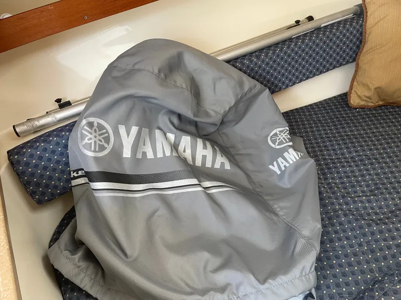 Slide: The Image of A gray Yamaha cover rests on a cushioned bench with blue upholstery. - 3