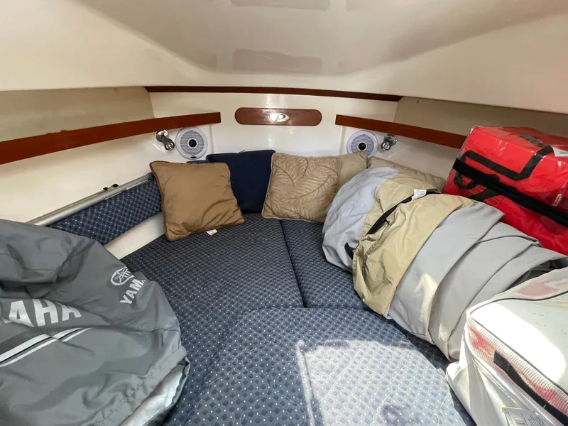 Slide: The Image of Interior of a 2008 Pursuit OS 285 Offshore with cozy cushions and storage space. - 4