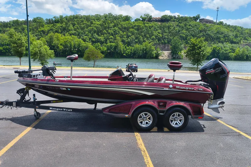 The Image of 2022 Ranger Z518 boat parked by a scenic river with lush green hills. - 0