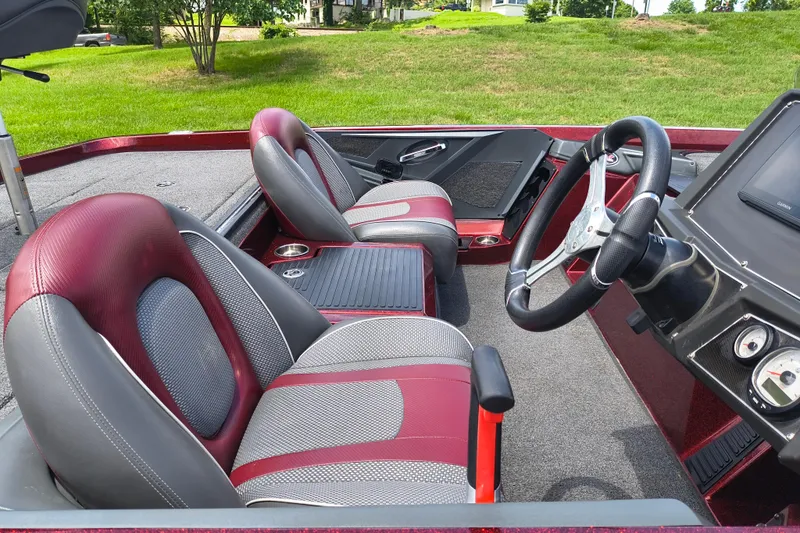 Slide: The Image of 2022 Ranger Z518 boat interior with red and gray seats, steering wheel, and dashboard. - 12