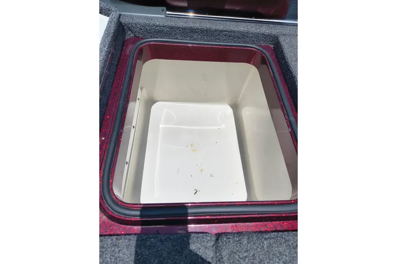 Slide: The Image of 2022 Ranger Z518 boat storage compartment with red trim and carpeted edges. - 14
