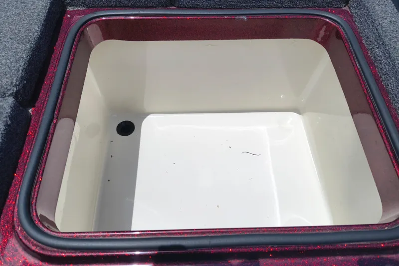 Slide: The Image of 2022 Ranger Z518 boat storage compartment with red trim and carpeted edges. - 15