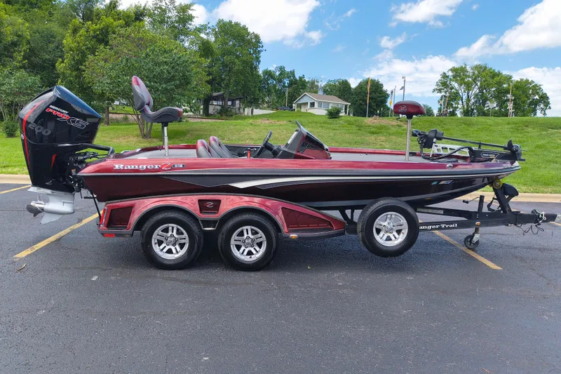 Slide: The Image of 2022 Ranger Z518 boat with trailer, parked outdoors on a sunny day. - 2