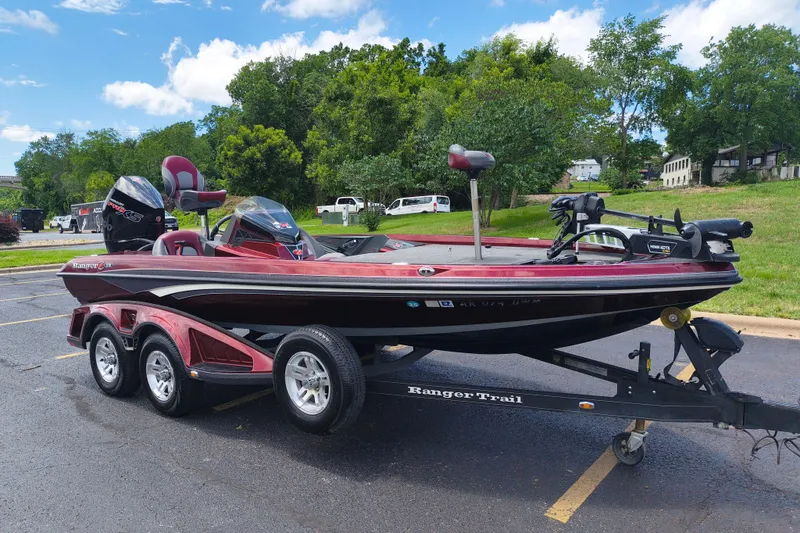 Slide: The Image of 2022 Ranger Z518 bass boat on trailer in parking lot, surrounded by greenery. - 3