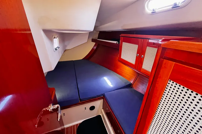 Slide: The Image of Cozy cabin interior of 2004 Hanse 411 yacht with wooden cabinetry and blue cushions. - 11