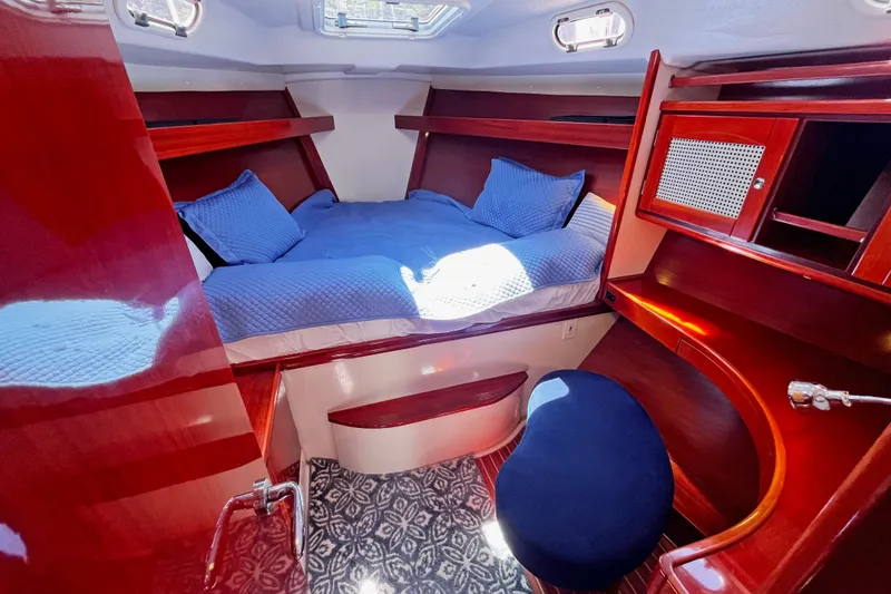 Slide: The Image of Luxurious cabin interior of a 2004 Hanse 411 yacht with blue bedding and wooden furnishings. - 2