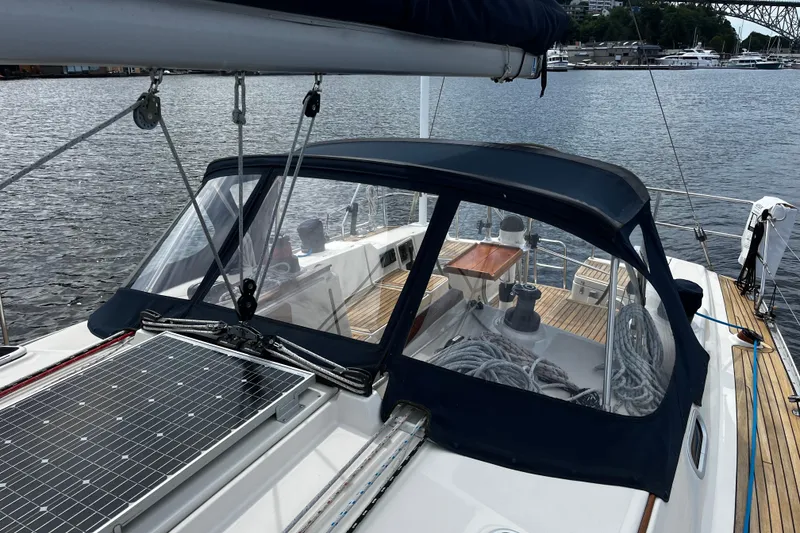 Slide: The Image of 2004 Hanse 411 sailboat with solar panel and cockpit cover, docked by the water. - 25