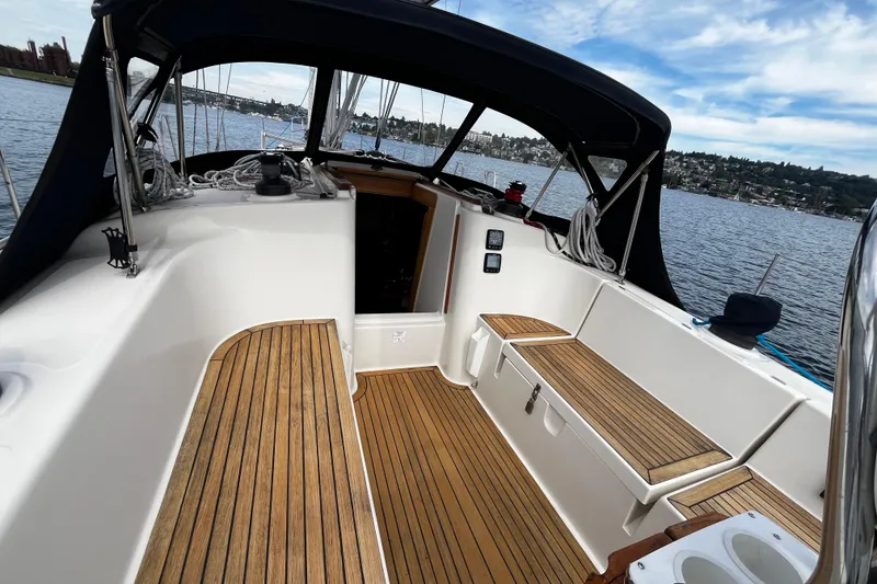 Slide: The Image of 2004 Hanse 411 sailboat cockpit with teak flooring, docked on a scenic waterfront. - 26