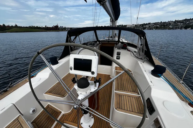 Slide: The Image of 2004 Hanse 411 sailboat cockpit with steering wheel and navigation system on calm water. - 30