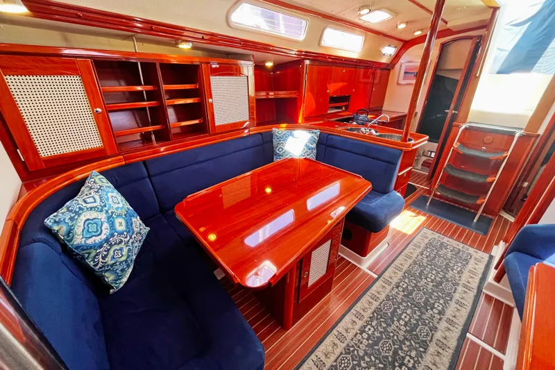 Slide: The Image of Luxurious 2004 Hanse 411 yacht interior with polished wood, blue seating, and elegant decor. - 4