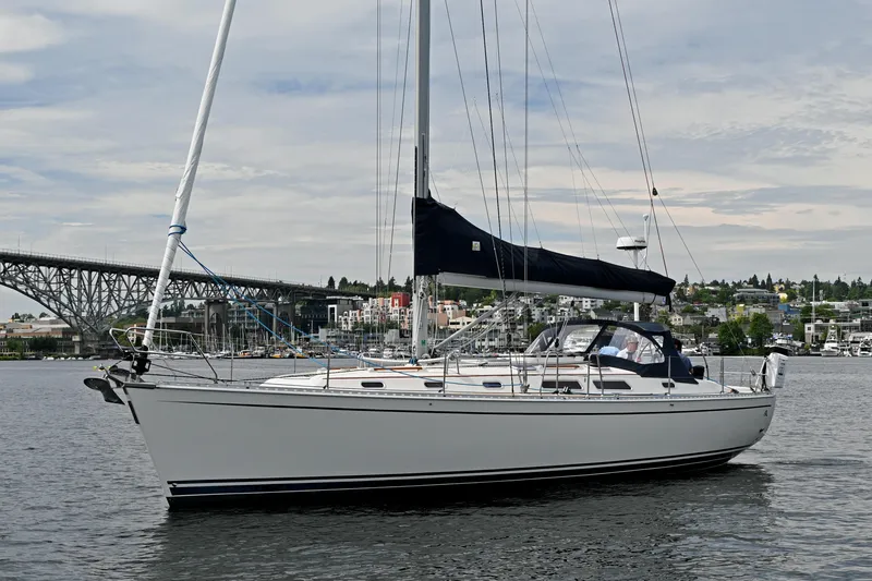 Slide: The Image of 2004 Hanse 411 sailboat on calm water near a bridge and cityscape. - 46