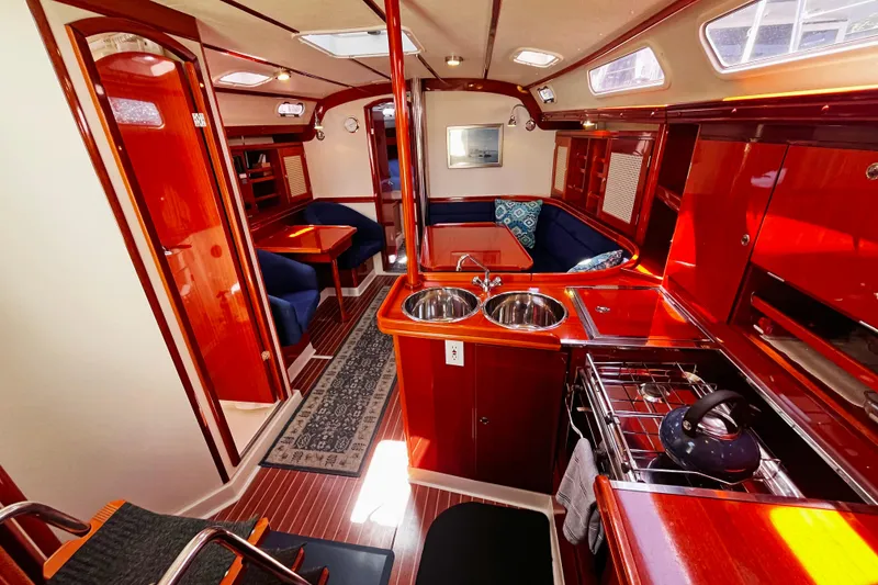 Slide: The Image of Luxurious 2004 Hanse 411 yacht interior with polished wood, cozy seating, and modern kitchen amenities. - 9