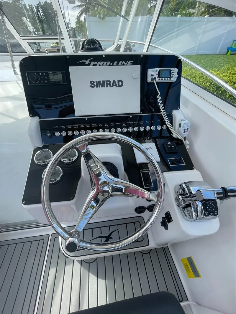 Slide: The Image of The helm of a Pro-Line 32 Express boat with modern navigation equipment. - 10
