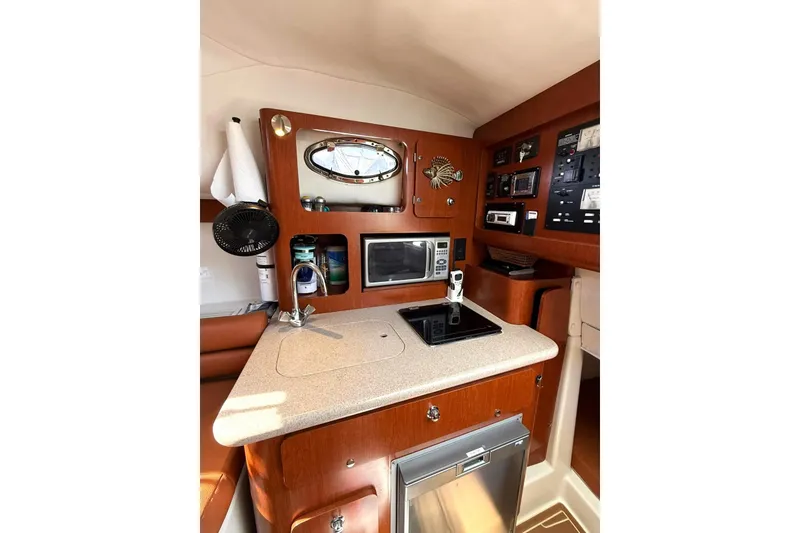 Slide: The Image of 2006 Pro-Line 32 Express boat interior with kitchenette, featuring microwave and control panel. - 12