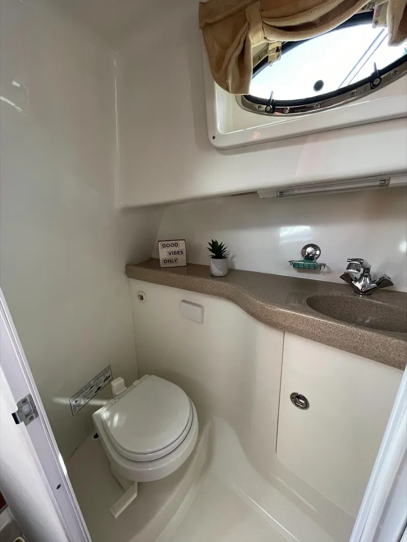 Slide: The Image of Interior of a boat cabin with a toilet, sink, and window. - 16
