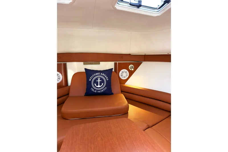 Slide: The Image of Interior of 2006 Pro-Line 32 Express boat with cozy seating and nautical-themed pillow. - 18