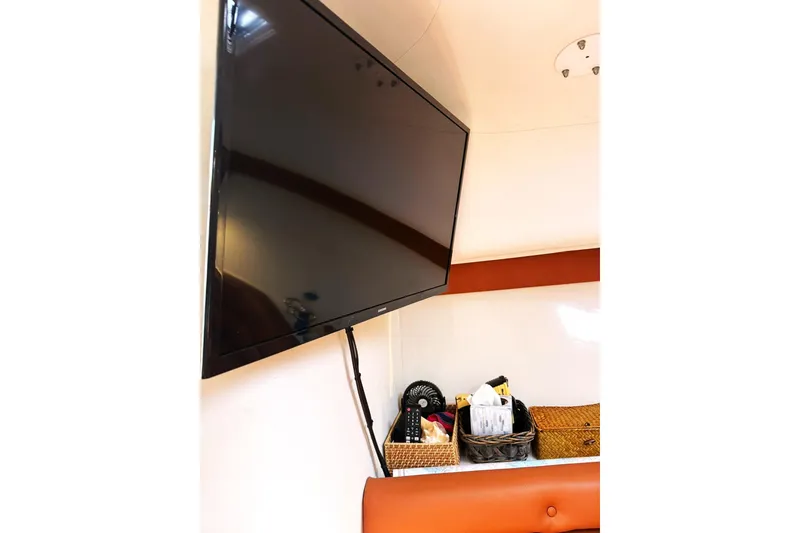 Slide: The Image of Flat-screen TV and storage baskets inside 2006 Pro-Line 32 Express boat cabin. - 21