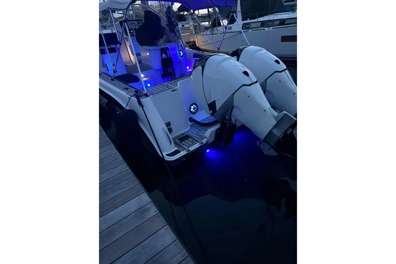 Slide: The Image of 2006 Pro-Line 32 Express boat with illuminated deck and dual outboard motors at dock. - 28