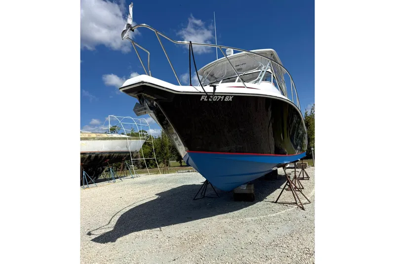 Slide: The Image of 2006 Pro-Line 32 Express boat on stands, under clear blue sky. - 3