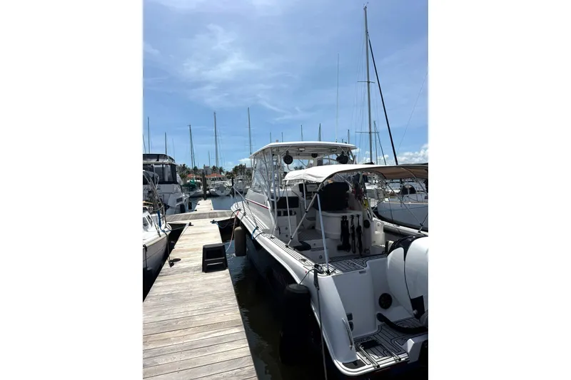 Slide: The Image of 2006 Pro-Line 32 Express boat docked at marina under clear blue sky. - 32