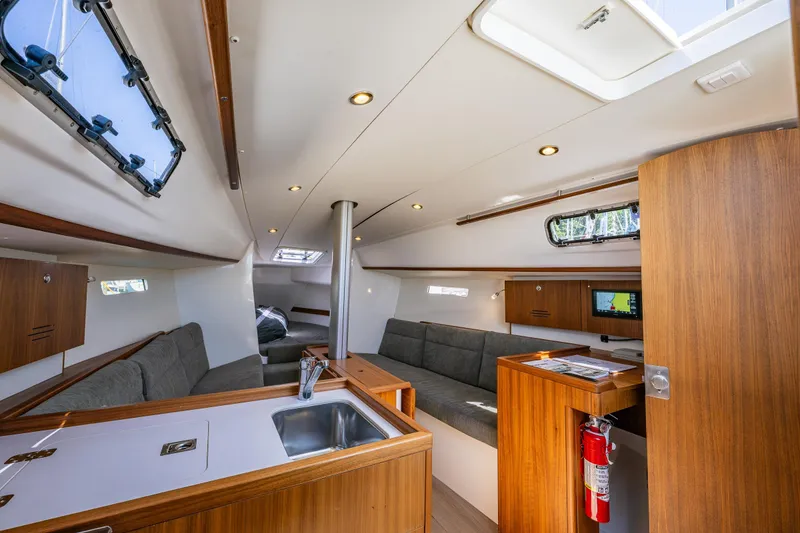 Slide: The Image of Interior of 2018 J Boats J/97E sailboat with modern wood finish and seating area. - 13