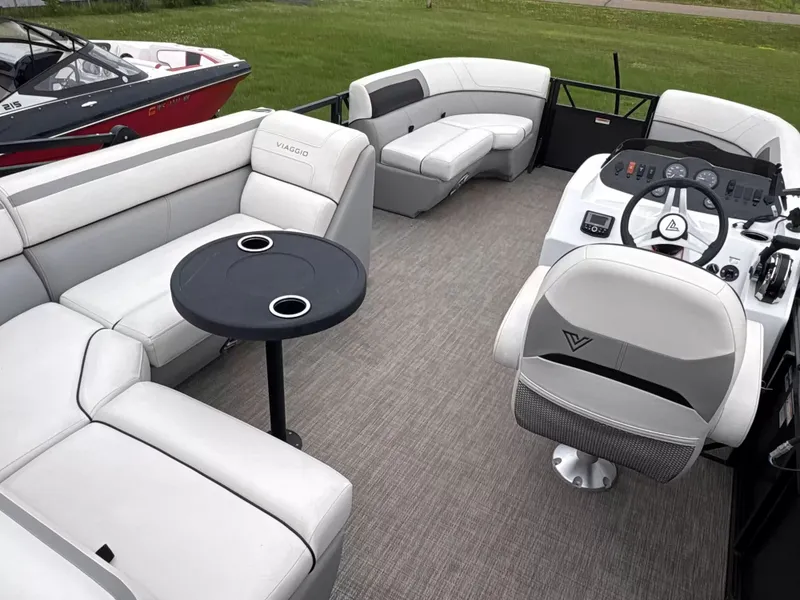 Slide: The Image of Interior of a Viaggio L20C pontoon boat with gray seating and a small table. - 7