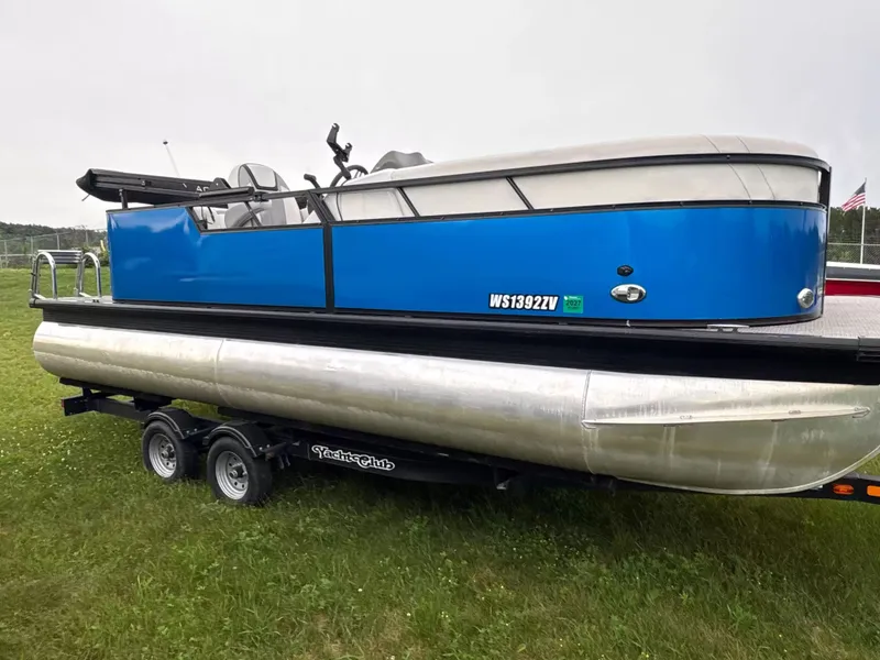 The Image of A blue 2021 Viaggio L20C pontoon boat on a trailer in a grassy area. - 1