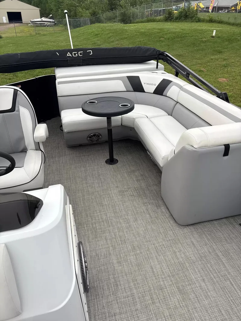 Slide: The Image of Interior of a Viaggio L20C pontoon boat with gray upholstery and a round table. - 5