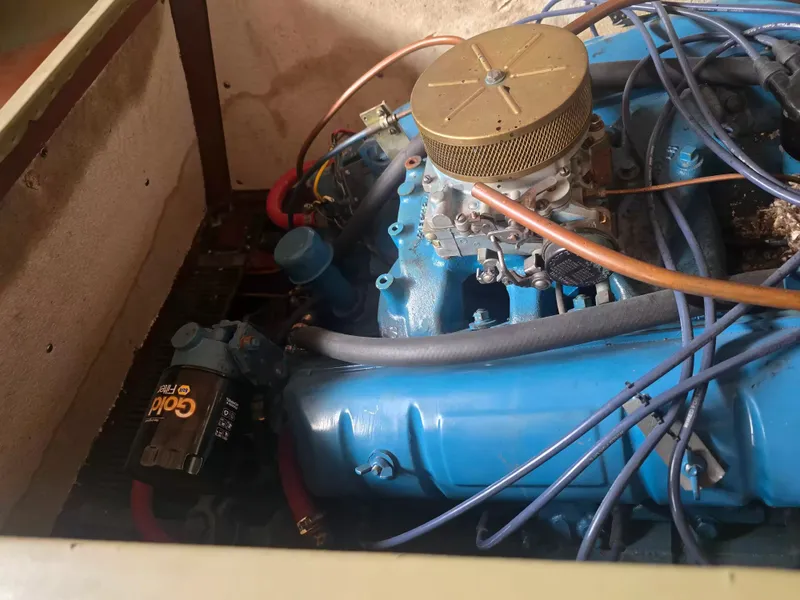 Slide: The Image of A blue engine with hoses and wires in a boat engine compartment. - 7