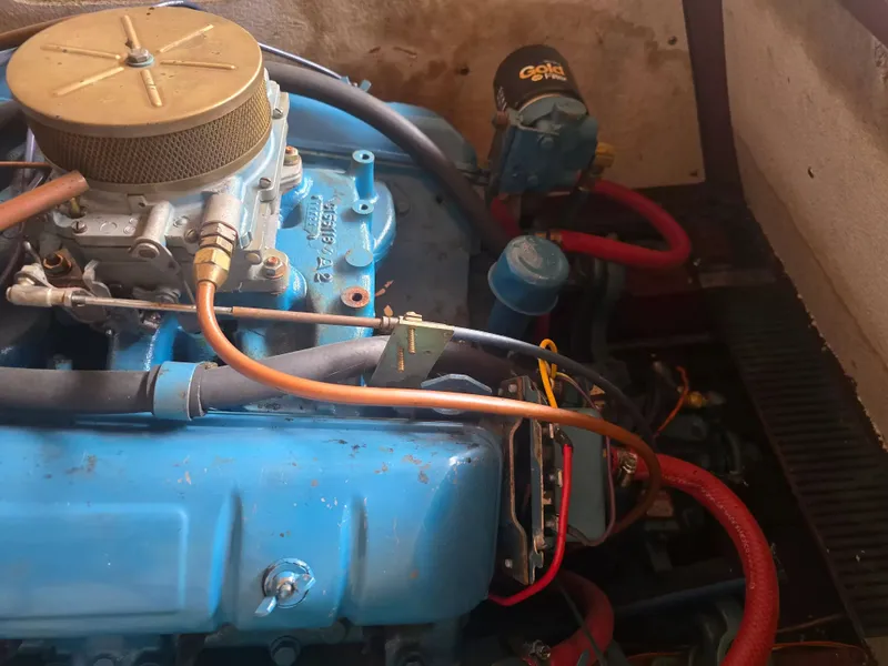 Slide: The Image of An engine compartment with a blue engine and red hoses. - 6