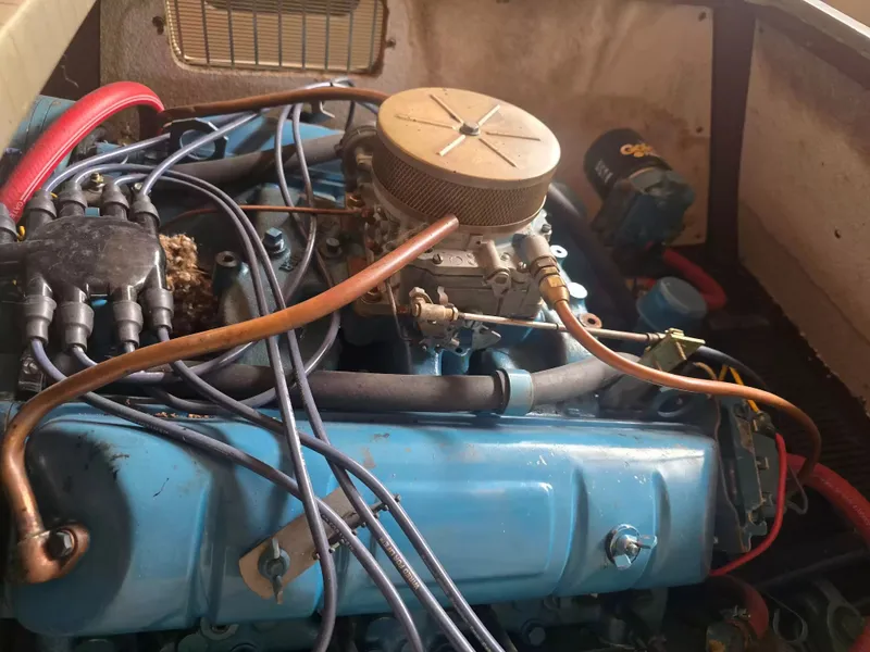 Slide: The Image of An engine inside a boat, featuring blue components and wires, in an open compartment. - 5