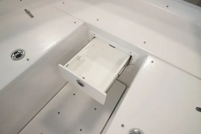 Slide: The Image of A white storage compartment with a pull-out drawer on a boat. - 46