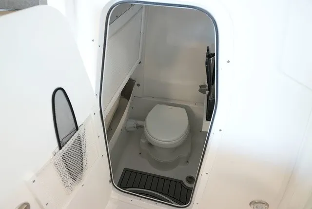 Slide: The Image of The image shows a compact, modern boat toilet with white walls and a small window. - 40