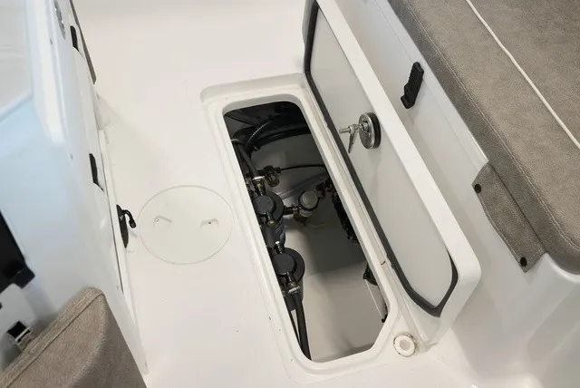 Slide: The Image of An open storage compartment on a boat with visible valves and hoses. - 16