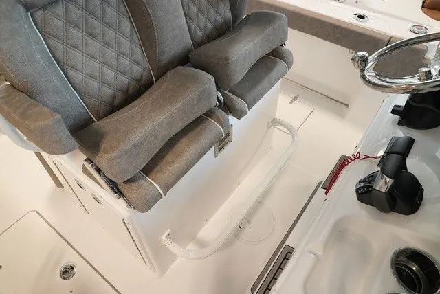 Slide: The Image of The image shows the helm of a Sea Hunt Ultra 265SE boat with cushioned seats. - 30