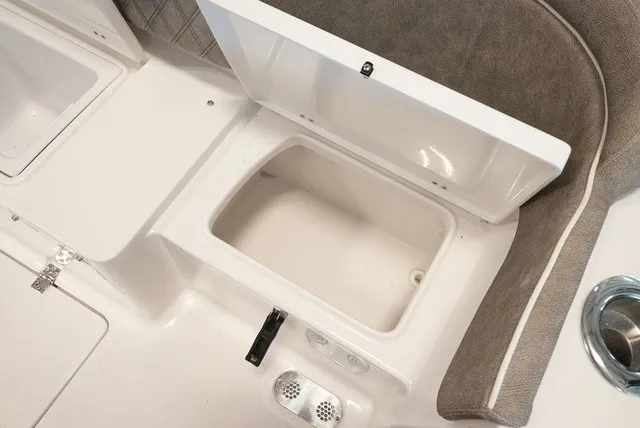 Slide: The Image of An open storage compartment on a boat with cushioned seating and a cup holder. - 15