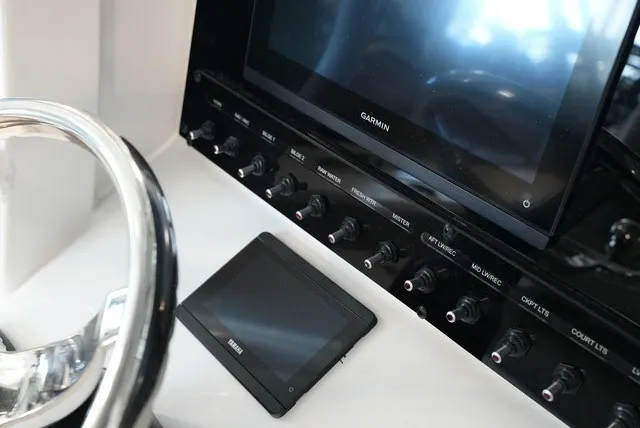 Slide: The Image of The image shows the dashboard of a Sea Hunt Ultra 265SE with multiple switches and a screen. - 37