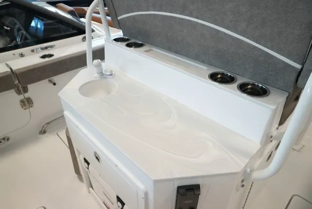 Slide: The Image of The 2027 Sea Hunt Ultra 265SE features a sleek white countertop with an integrated sink and cup holders. - 20