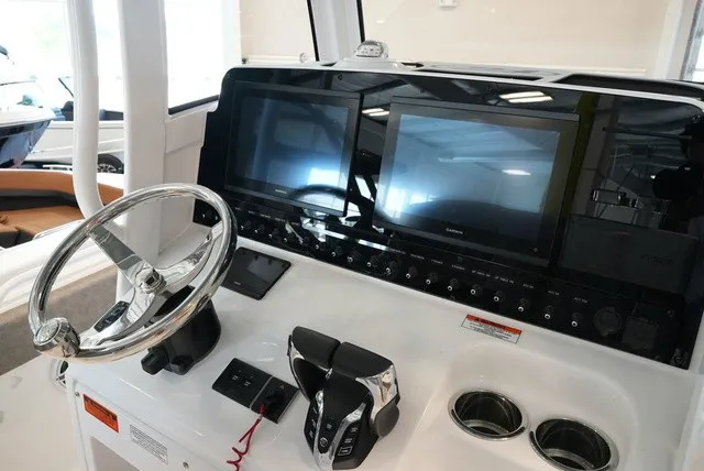 Slide: The Image of The image shows the helm of a Sea Hunt Ultra 265SE boat with modern screens and controls. - 36