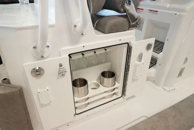 Slide: The Image of An open storage compartment with cup holders and glasses inside a boat. - 31