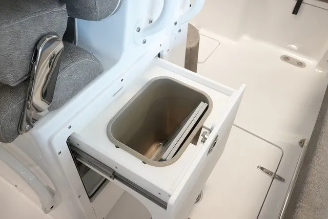 Slide: The Image of An open storage compartment on a boat with gray upholstery and white interior. - 33