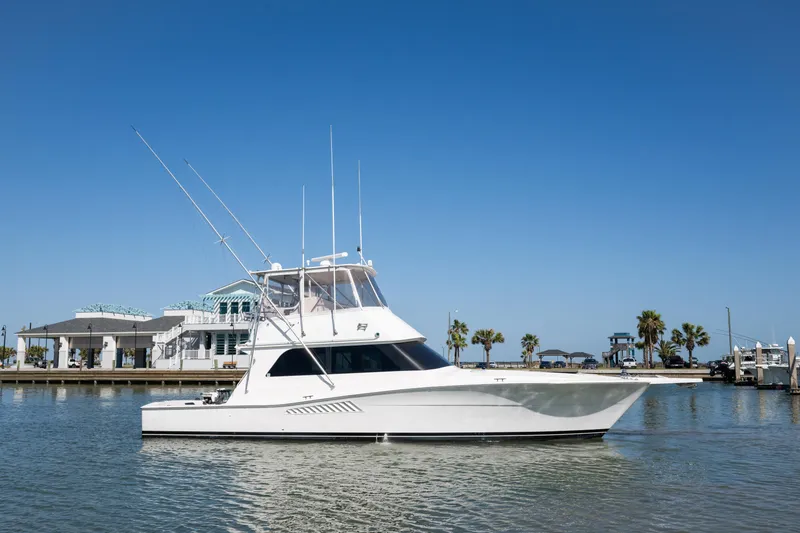 The Image of 1999 Viking 47 Convertible yacht on calm water with clear blue sky. - 1