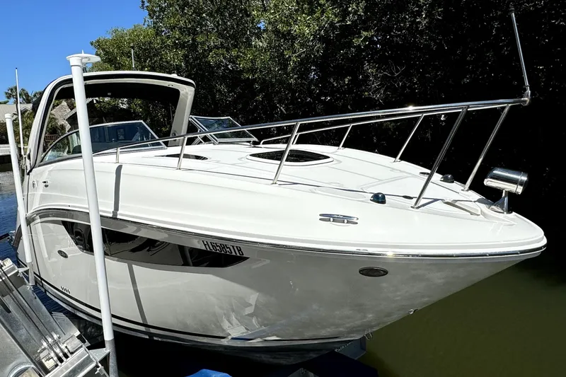 The Image of 2018 Sea Ray Sundancer 260 boat docked near lush greenery. - 0