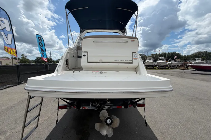 Slide: The Image of 2018 Sea Ray Sundancer 260 boat with blue canopy, displayed outdoors under cloudy sky. - 3
